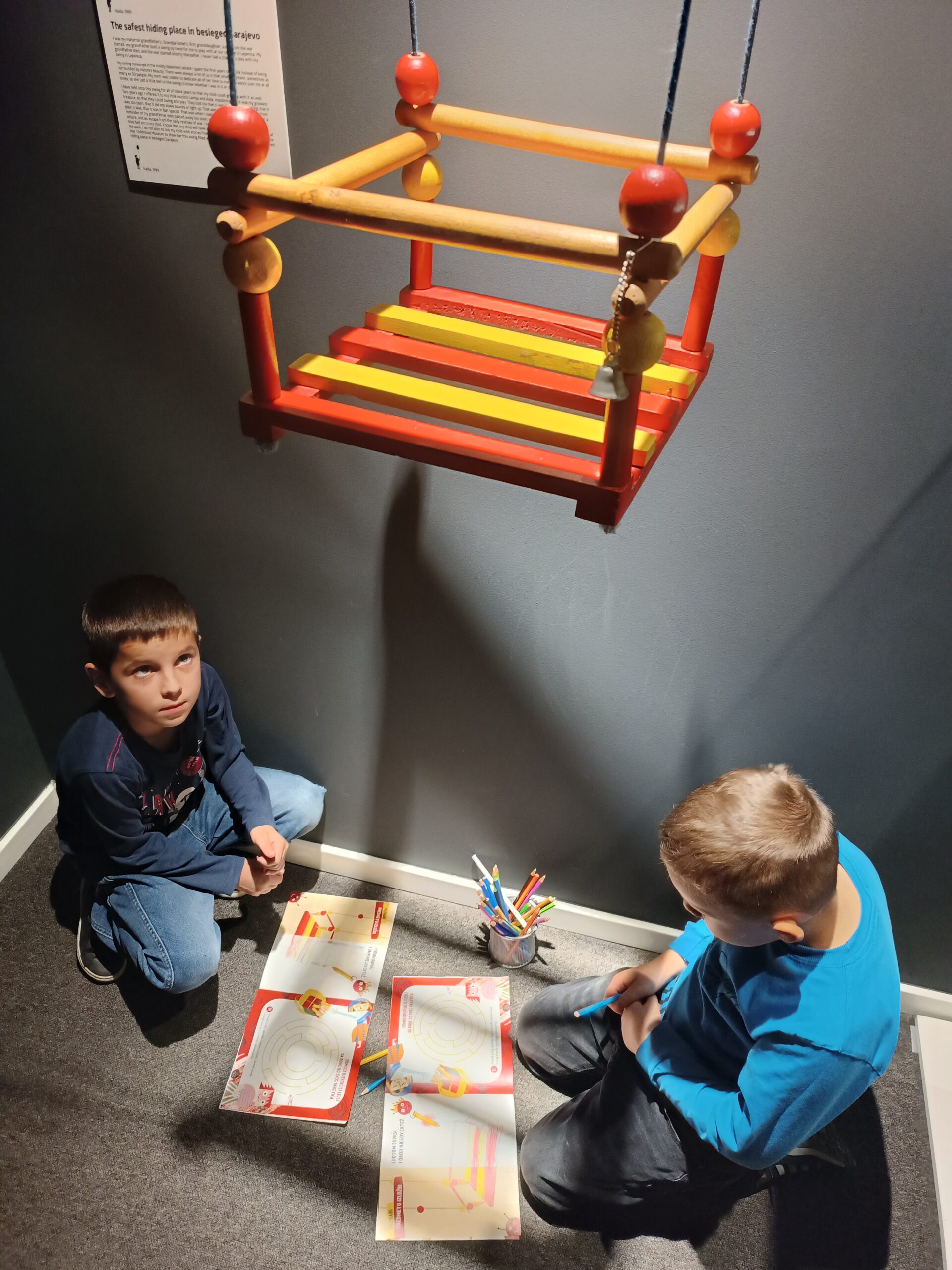 Dvojica dječaka koriste vodiče ispod eksponata ljulje