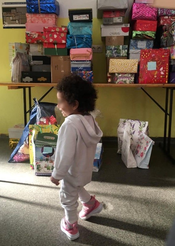 Bihac-gift-giving Child in front of gift packages